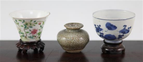 Two Chinese porcelain cups and a small crackle glaze vase, 17th - 19th century, 4.8cm., with wood stand